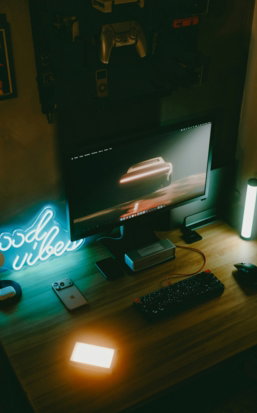 desk-with-computer--neon-sign--and-gaming-accessories-.jpg Desk with computer, neon sign, and gaming accessories.